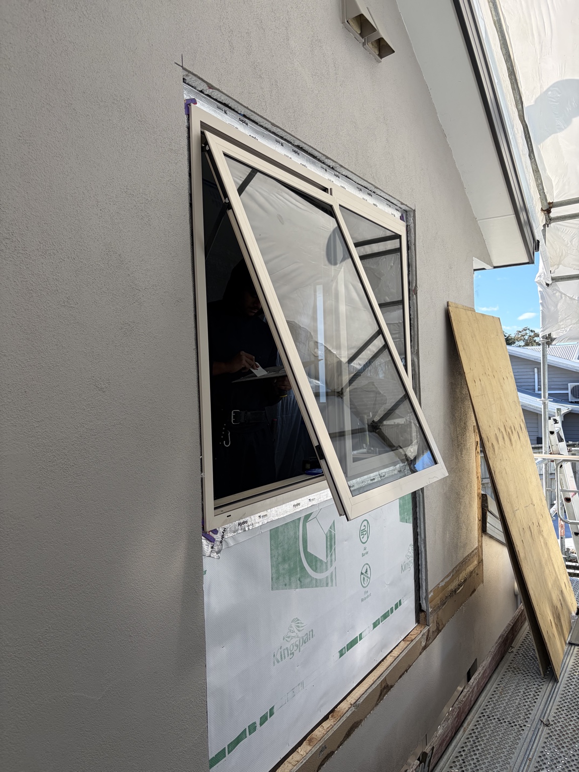 New aluminium window being installed in the upper-level wall
