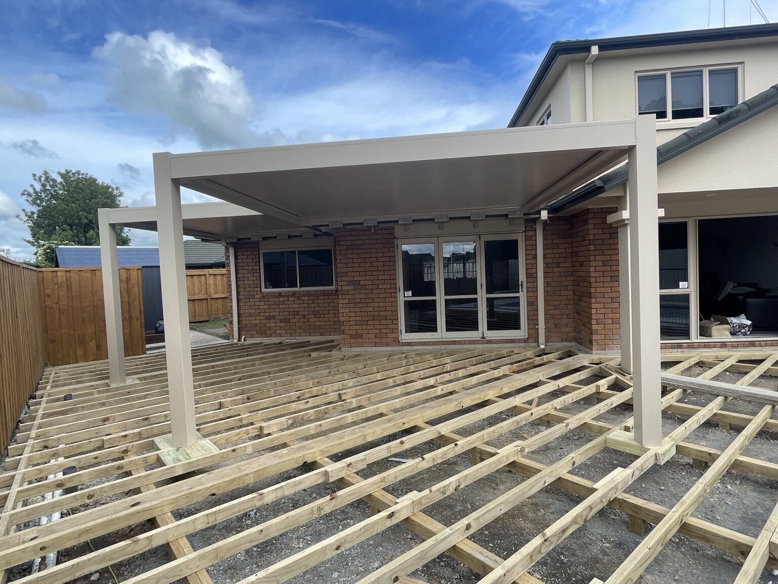 Completed pergola structure above extensive timber deck framing