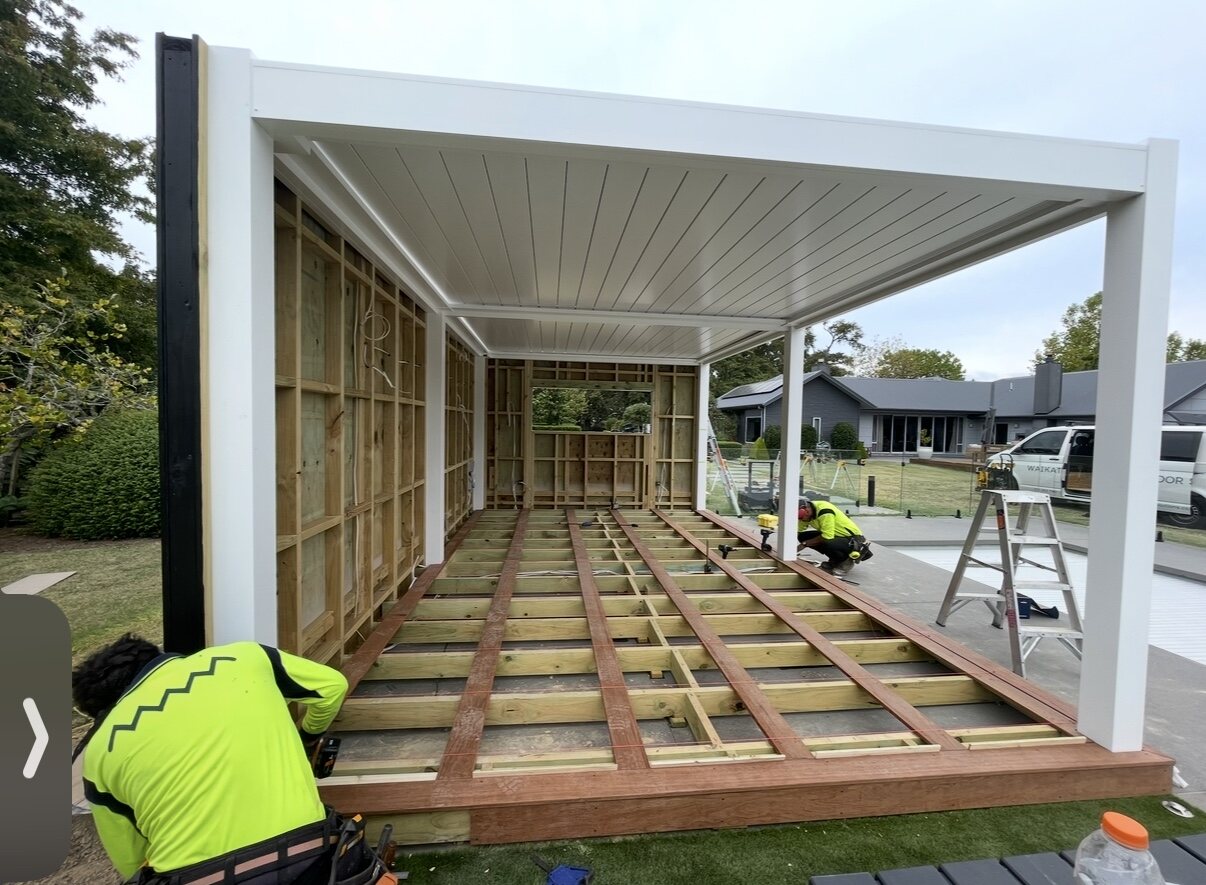GRIT team installing a white louvre pergola over a new deck